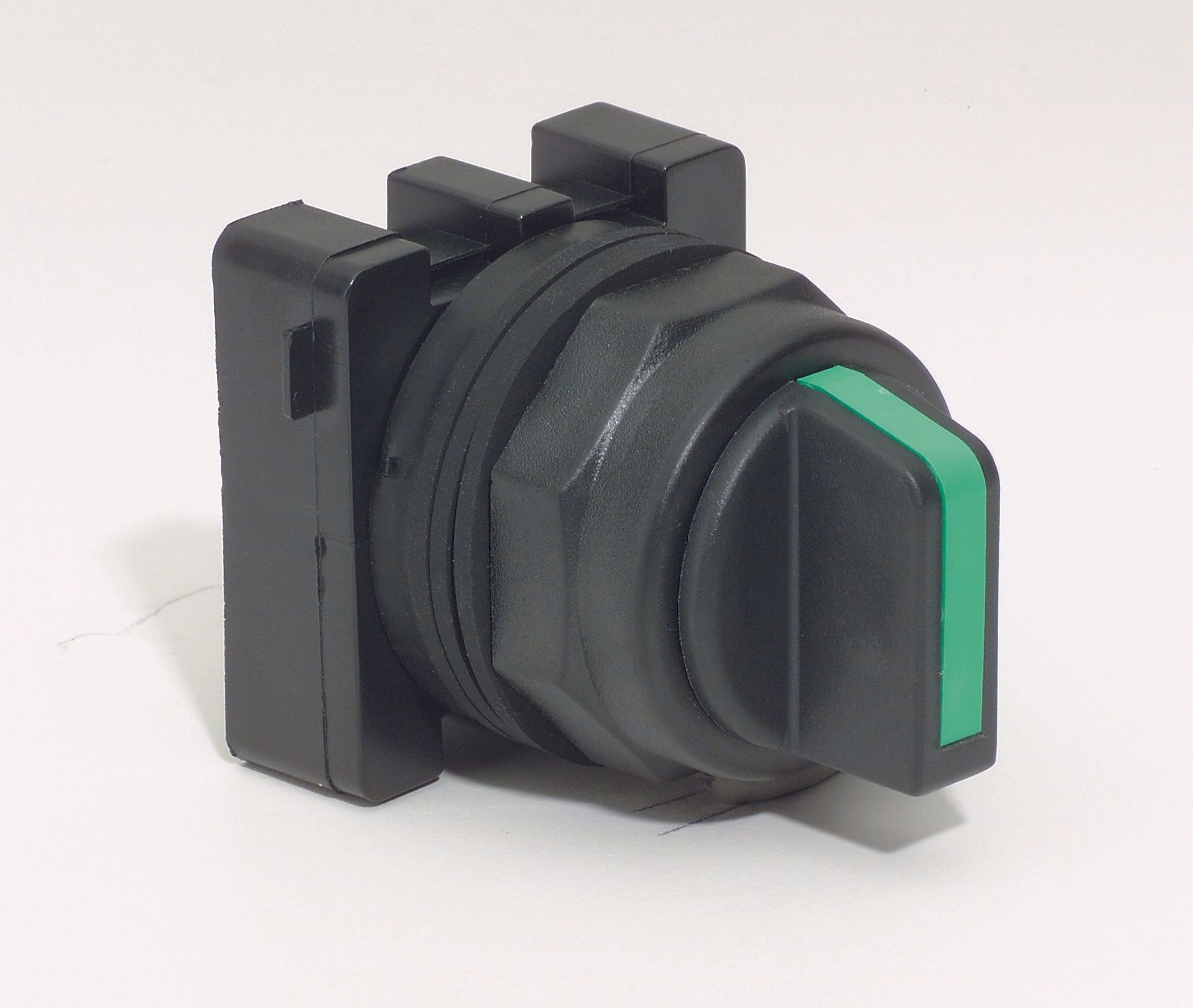 Black industrial rotary selector switch with a green indicator line on the knob